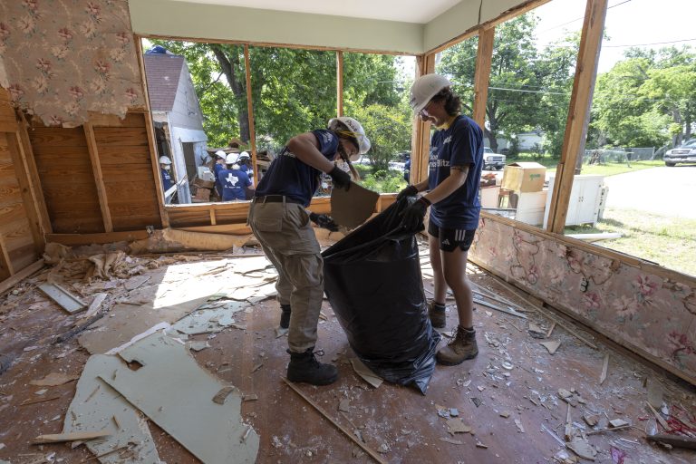 TEMPLE, TEXAS, USA (05/15/2023) - TeamUp! AmeriCorps member with Catholic Charities, Page Tazewell, and AmeriCorps National member, based out of the Charlotte region, HFH of (NC), Rissa Martin, volunteer by clearing out this Habitat house during the National Service Blitz build, hosted by Fort Hood Area Habitat in Central Texas. Demolition has begun on this house in Temple, Texas. This house has been abandoned for several years and has recently been donated to Habitat for Humanity. Once renovations are finished, a new family will soon call this house their home. © Habitat for Humanity International/Meghan Cronin.